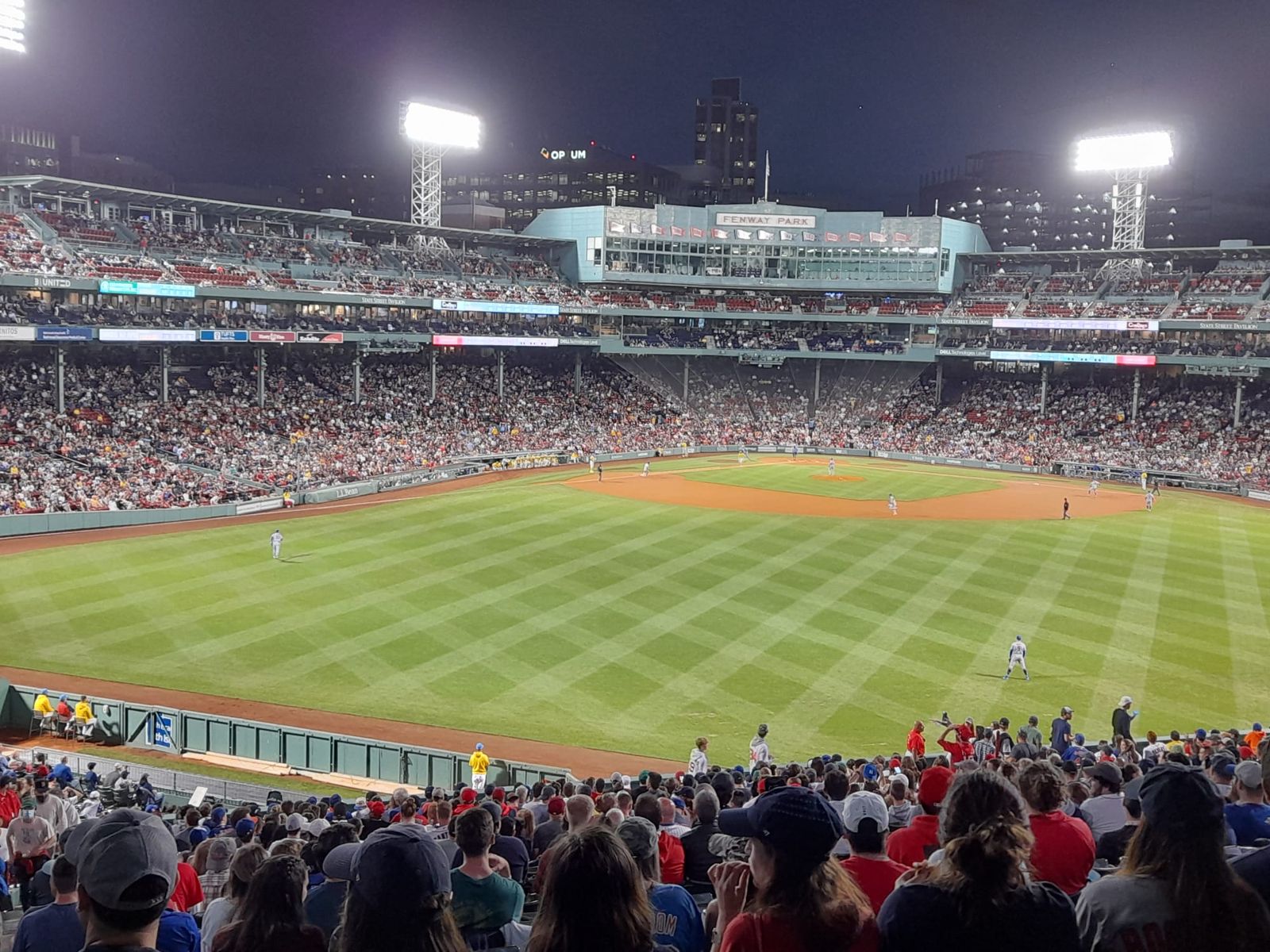 A packed evening crowd watching a baseball game at Fenway Park in Boston.